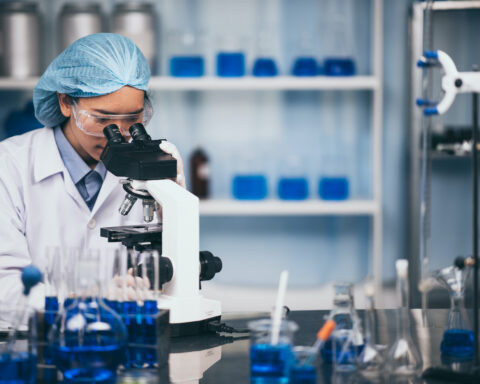 Young scientist looking through a microscope in the laboratory
