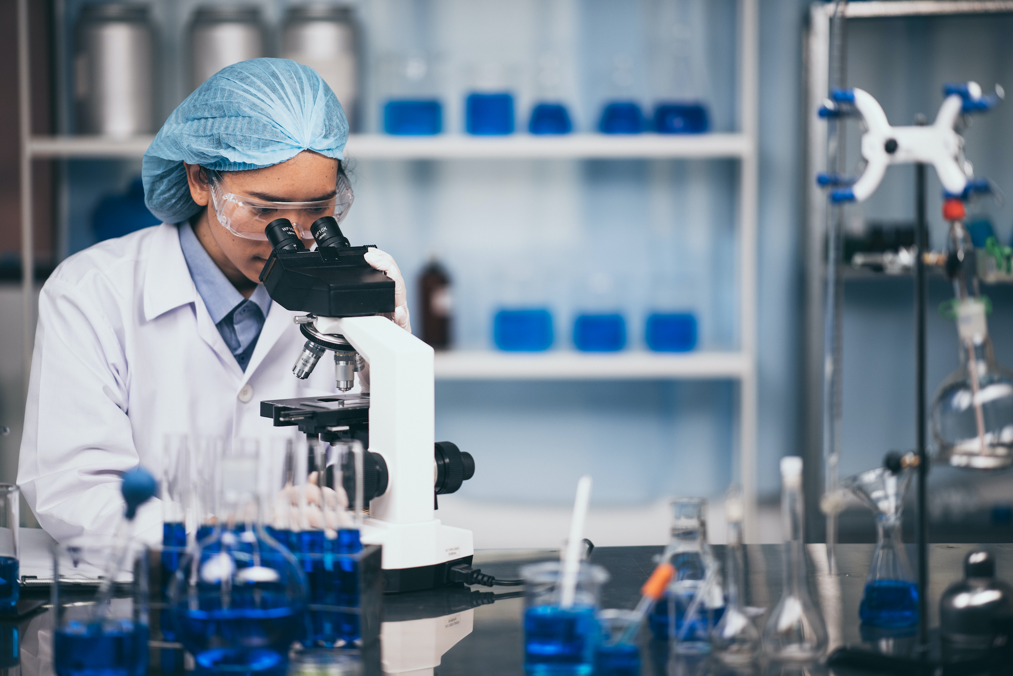 Young scientist looking through a microscope in the laboratory