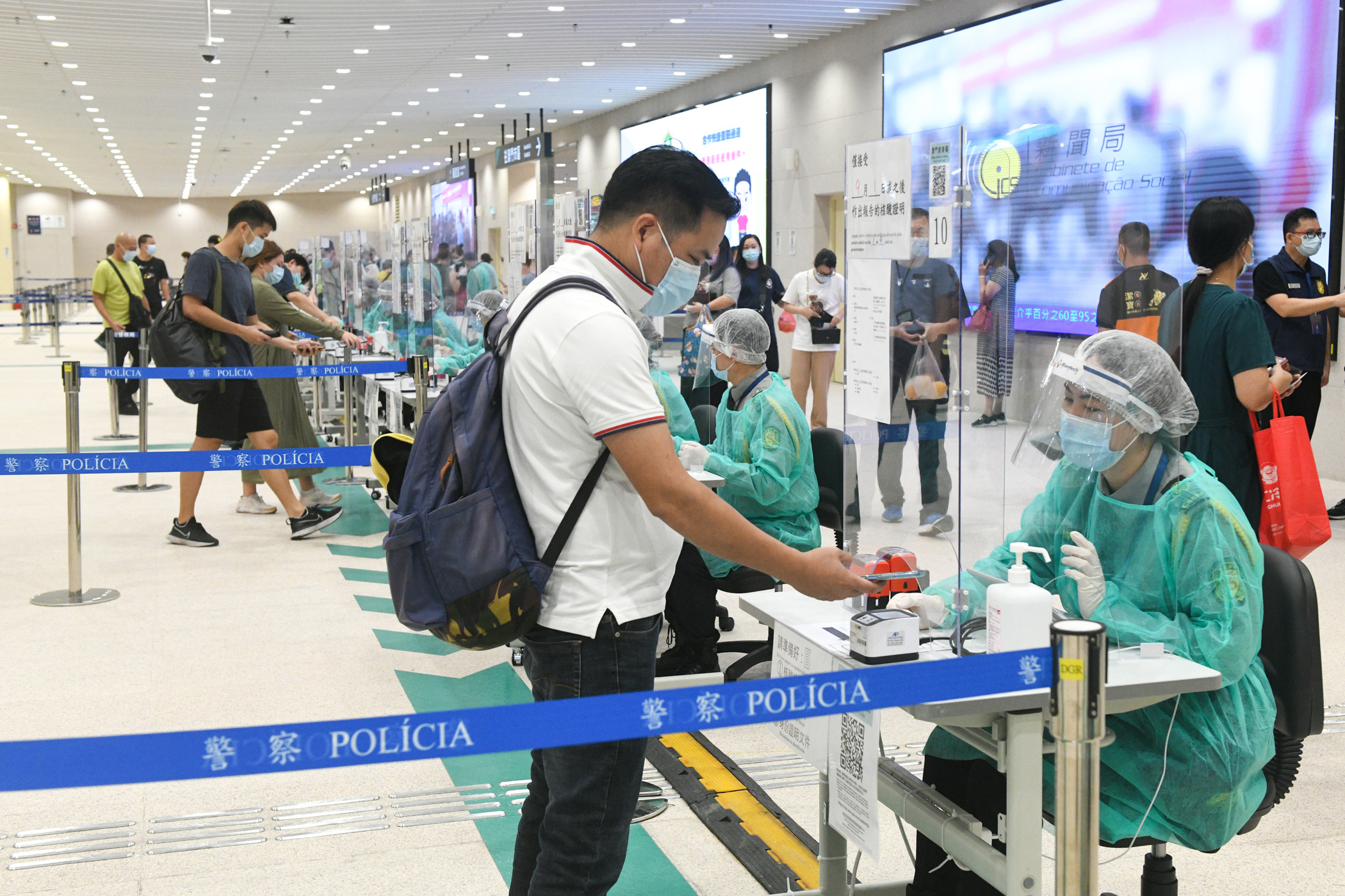 Travellers participate in a series of Covid-19 prevention measures at the border