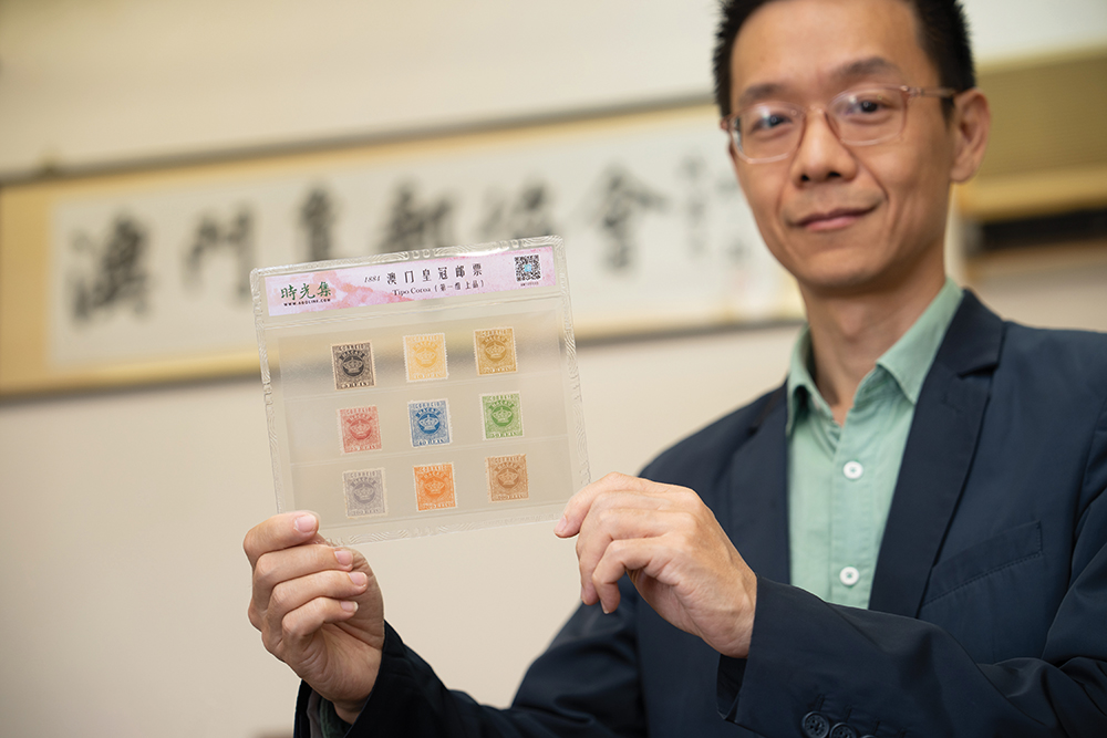 Huo Hui Xiao holding the pride of his collection: Macao’s first ever stamps