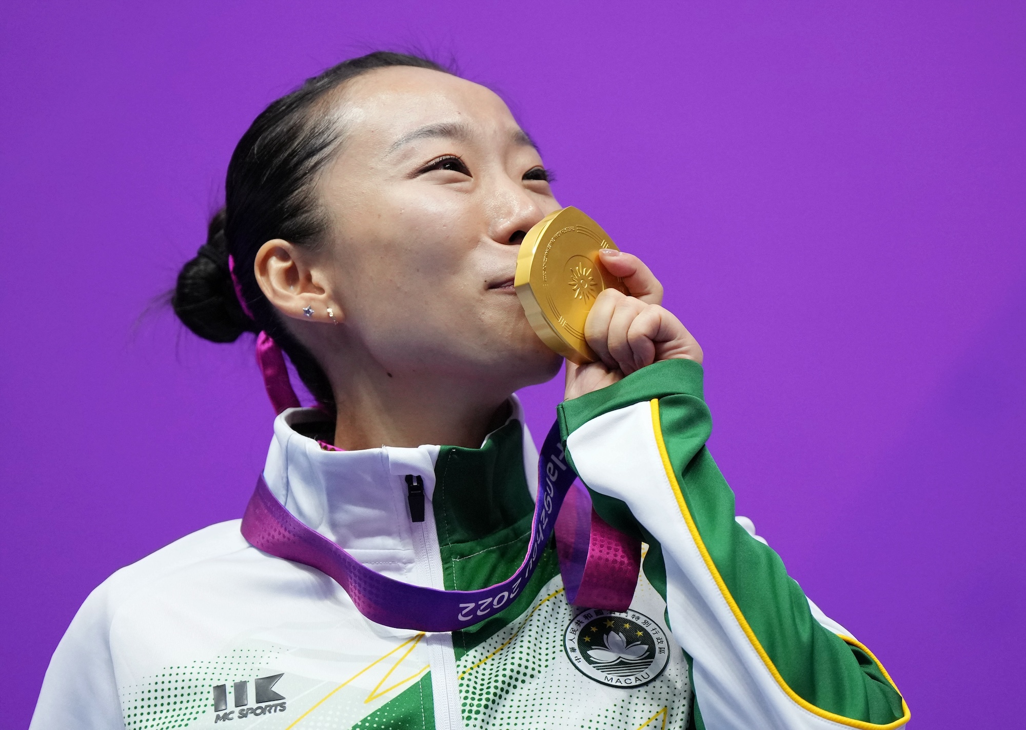 Li Yi kisses her gold medal at last year's Asian Games in Hangzhou