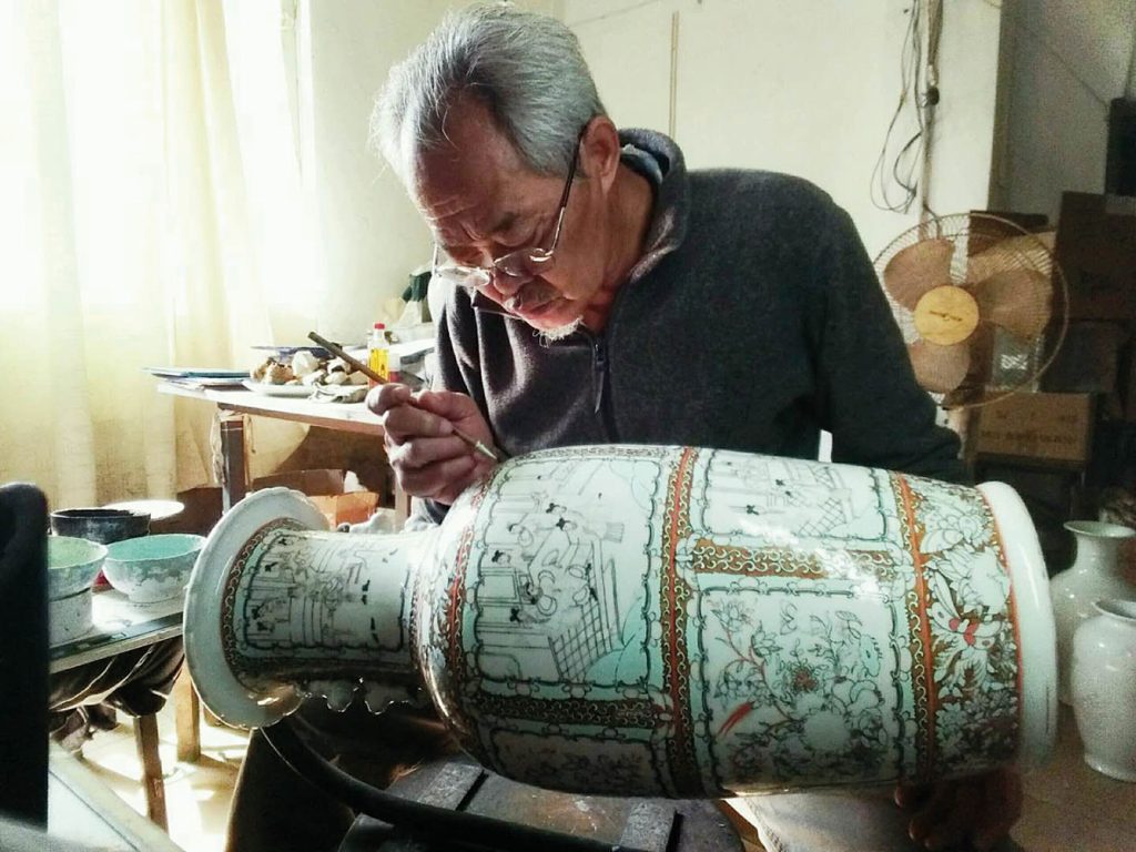 The artist working on a large vase