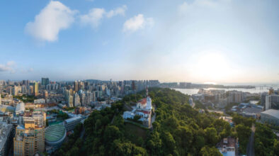 A 17th-century fort looks out from the dense green of Guia Hill to the busy, modern city below