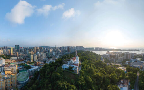 A 17th-century fort looks out from the dense green of Guia Hill to the busy, modern city below