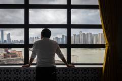 A guest contemplates the soaring skyscrapers of Zhuhai from a room at the Grande Hotel