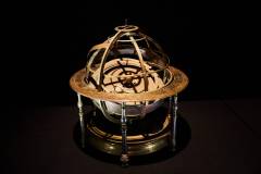 A gilt-bronze armillary orrery, which is a mechanical model of the solar system that illustrates the positions and motions of the planets and moons, with seven celestial bodies displayed. This is from the 18th century.