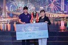 A representatitve from the winning team (left) receives a cheque from the Macao Government Tourism Office’s Maria Helena de Senna Fernandes