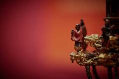 Around the base of the pavilion, a series of tiny detailed figures stand atop dragon heads