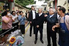 He greeted merchants and passersby as he toured the temporary pedestrian zone in Taipa Village