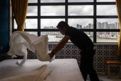 A staff member services a guest bedroom at the recently renovated Grande Hotel