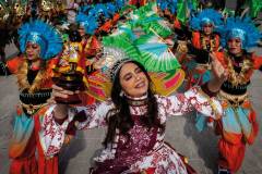 The queen of Orient Premier Tribe dance troupe holds a small statue of the Infant Jesus as she leads her group in a performance