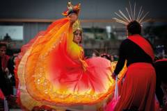 Clad in a kaleidoscope of colours, a devoted dancer holds up the sacred figure of the Infant Jesus